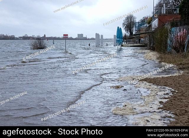 20 December 2023, Hamburg: The water of the Elbe washes over parts of the beach in Hamburg-Övelgönne at high tide. The Federal Maritime and Hydrographic Agency...