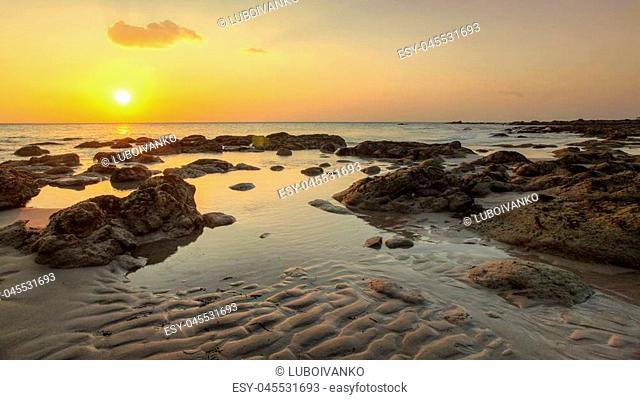 Beach in golden sunset light during low tide showing sand formations and rocks not covered by the sea. Kantiang Bay, Ko Lanta, Thailand