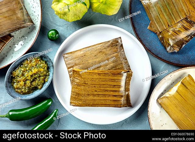Tamales oaxaquenos, traditional dish of the cuisine of Mexico, various stuffings wrapped in green leaves, overhead flat lay shot. Hispanic food