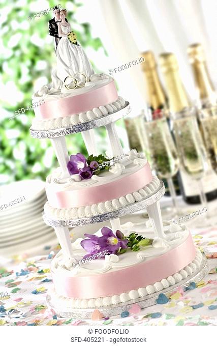 A three-tiered wedding cake with floral decoration Not available for exclusive usages