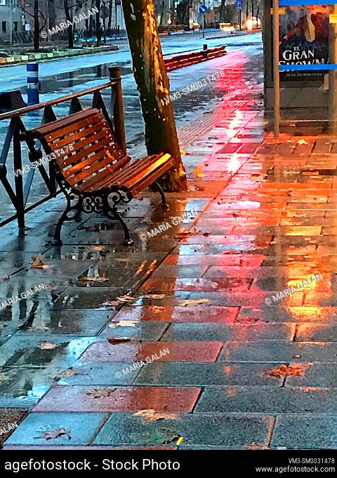 Bench in street in a rainy night. Madrid, Spain