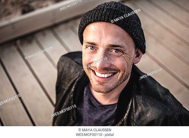 Portrait of smiling man with stubble wearing woolly hat