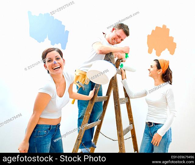 Young couple and friend improving their home