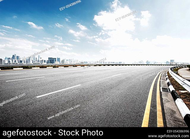 empty asphalt road and cityscape of hangzhou in blue sky