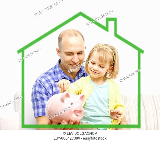 family, children, money, investments and happy people concept - happy father and daughter with big pink piggy bank behind green house symbol