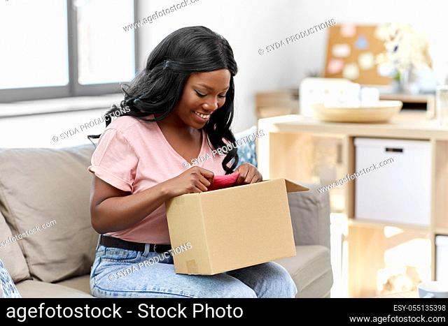 african american woman opening parcel box at home