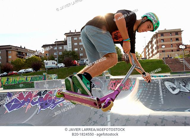 Teenager with city scooter in Skate park, Leioa, Bizkaia, Basque Country, Spain