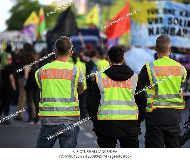 30 April 2018, Germany, Berlin: Police officers wearing reflective vests observe the situation in the course of a demonstration in Wedding district