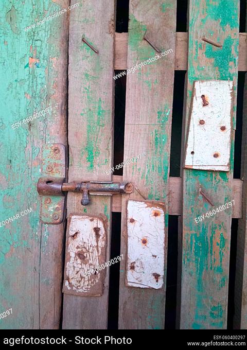 Old rusty bolt and padlock on a wooden door