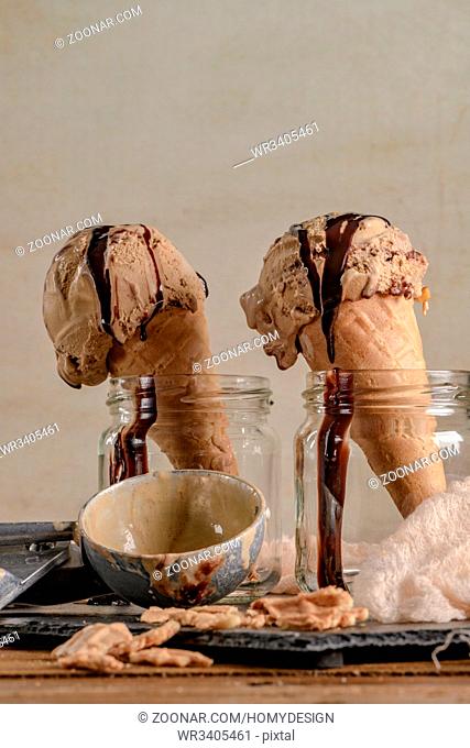 Homemade chocolate ice cream in waffle cones and pieces of dark chocolate