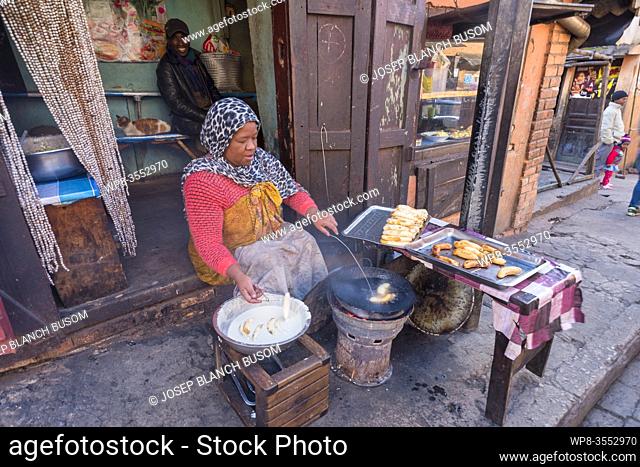 Malagasy woman frying banana fritters on a street stall in Morondava. Madagascar