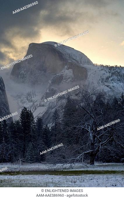 Storm clouds at sunrise and fresh snow in meadow below Half Dome, Yosemite Valley, Yosemite National Park, California