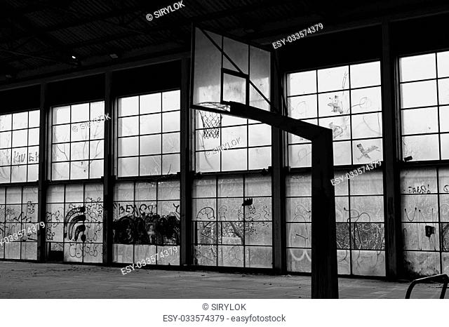 Abandoned basketball court gym interior and glass wall broken windows. Black and white