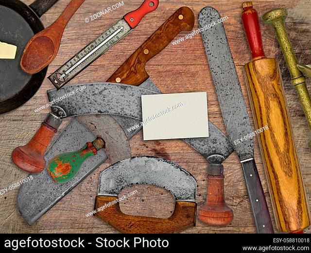 vintage bakery shop tools and utensils over stained wooden table, blank business card for your text