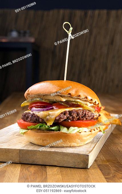 Hamburger on wooden background. For fast food restaurant design or fast food menu