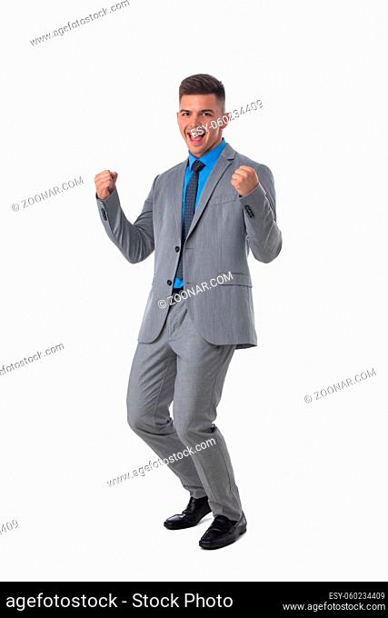 Young business man winner holding fists isolated on white background full length studio portrait