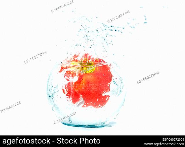 Red large pepper in water and splashes
