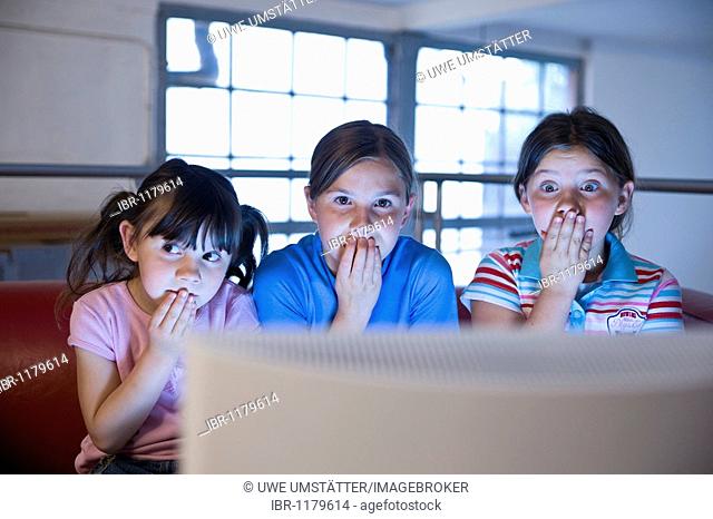 Three little girls secretly watching a video