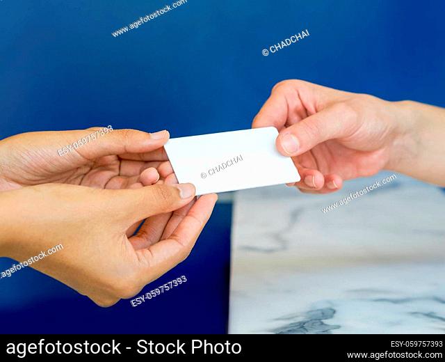 Close up woman hands reciving white plastic card