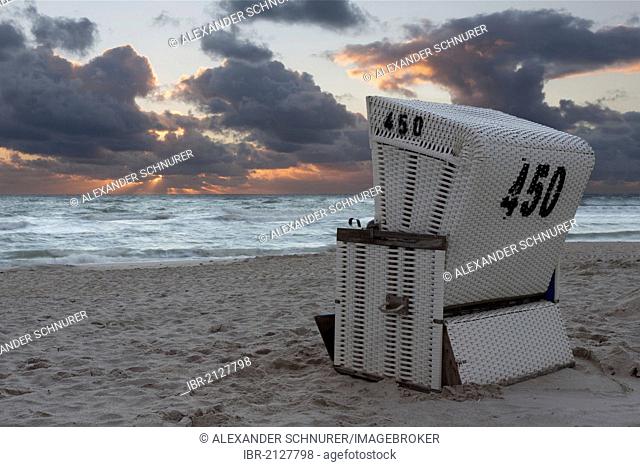 Roofed wicker beach chair on the beach just after sunset with dramatic clouds, Hoernum, Sylt, North Frisia, Schleswig-Holstein, Germany, Europe