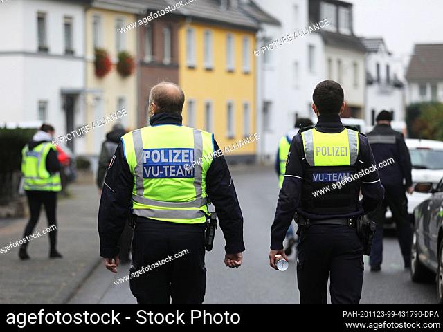 23 November 2020, North Rhine-Westphalia, Meckenheim: Forensic scientists and police officers go through a residential area for forensics