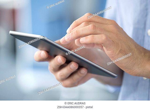 Man using digital tablet, close-up