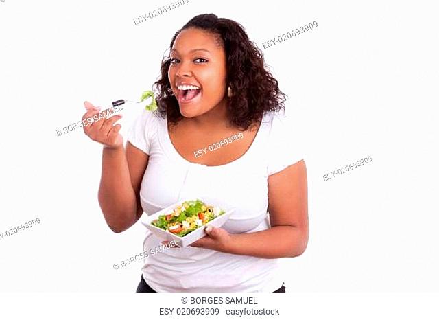 Young african american woman eating salad