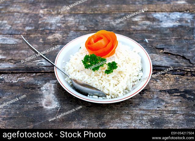 The plate with boiled rices on the old table
