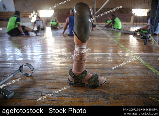 25 July 2020, Syria, Idlib City: A picture made available on 30 July 2020 shows a prosthetic leg backdropped by Syrian amputee men taking part in a sitting...
