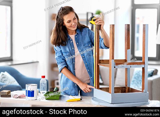 woman with ruler measuring table for renovation