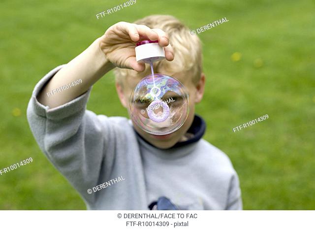 Boy  blowing soap bubbles