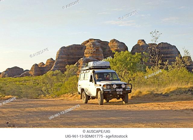 Four-wheel drive vehicle with beehive formations beyond, Purnululu National Park, Kimberley region, Western Australia