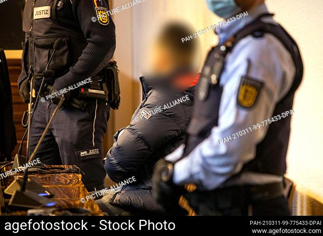 11 March 2021, Baden-Wuerttemberg, Freiburg: A defendant (M) sits in a courtroom of the Freiburg Regional Court. Two men convicted of a gang rape in Freiburg...