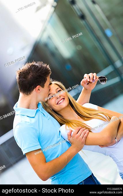 Adolescent teen couple together laughing happy, kiss in forehead