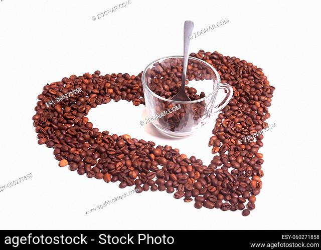 Grains of coffee and glass cup on white background