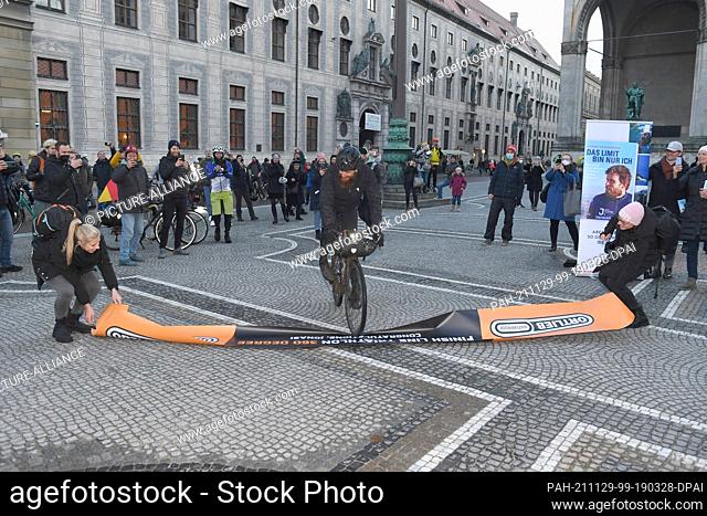 29 November 2021, Bavaria, Munich: German extreme athlete Jonas Deichmann rides to the finish of his triathlon around the world at Odeonsplatz