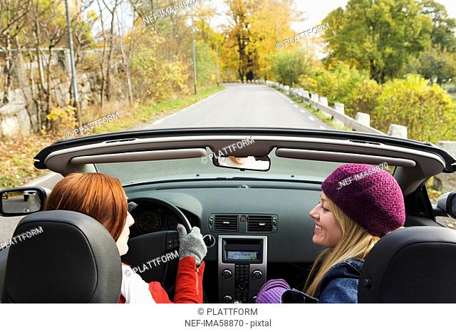 Two young women driving a cabriolet an autumn day Sweden