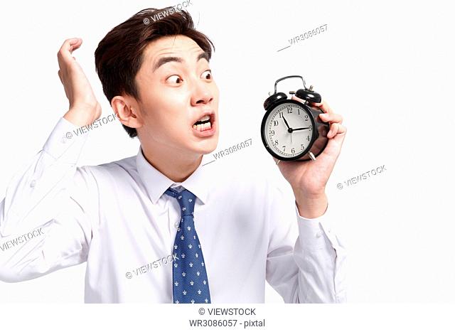 Shocking business young man with an alarm clock