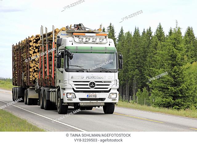 Hirvaskangas, Finland - June 15, 2018: White Mercedes-Benz Actros truck of Mikko Flyktman Oy pulls double timber trailer on highway 4 in the summer