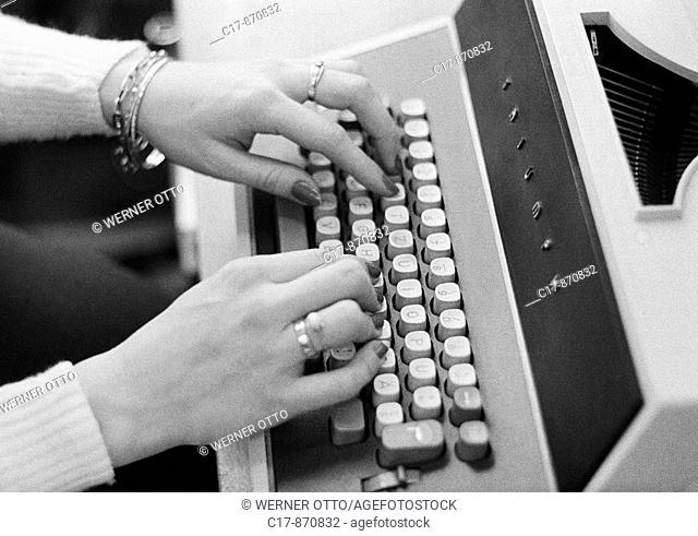 Seventies, black and white photo, economy, work, occupation, office clerk types on a typewriter, hands