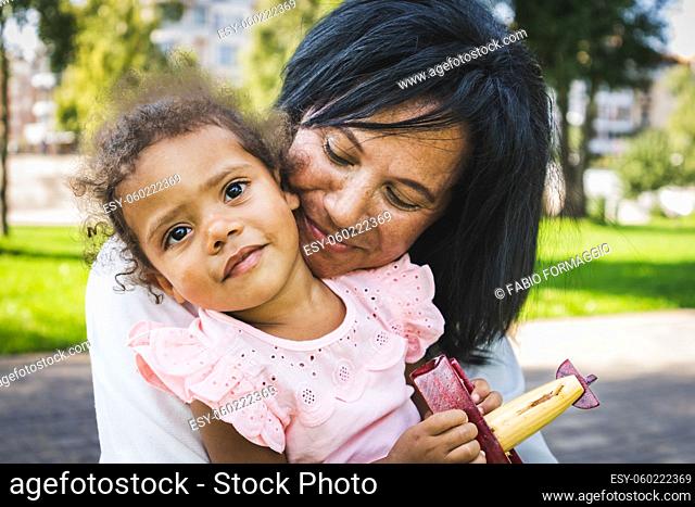 Beautiful happy african american family bonding at the park - Black family having fun outdoors, grandma cuddling her baby granddaughter