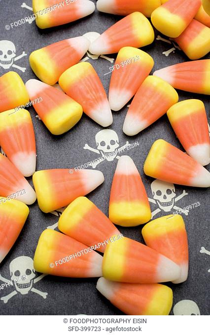 Candy corn on patterned background skulls and crossbones