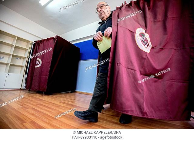 A man comes out of a polling booth with his ballot at a polling station in Istambul, Turkey, 16 April 2017. Turkish citizens are voting on a constitutional...