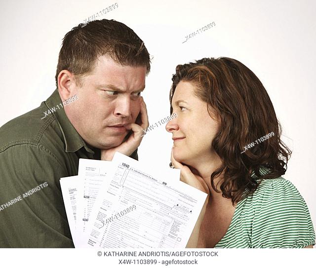 Married couple with United States 1040 tax forms feeling anxious about their taxes