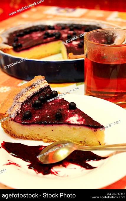 piece of fresh pie with bilberry on the plate and cup of tea
