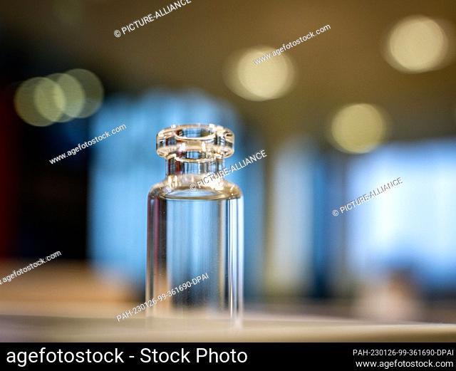 PRODUCTION - 25 January 2023, Rhineland-Palatinate, Mainz: A glass vial, such as those used for filling vaccines, stands on a table at the company headquarters...