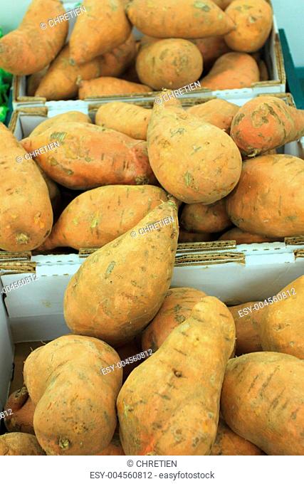 fresh sweet potatoes on a market stall