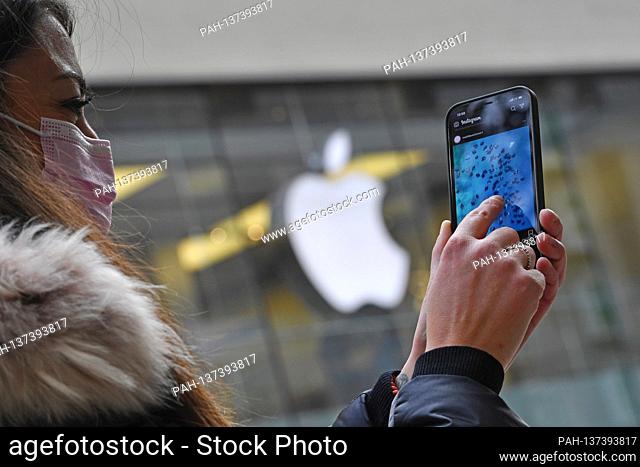 Mask compulsory in the pedestrian zones and public places in Munich on November 16, 2020. Young woman with everyday mask looks at her Apple Iphone 12 PRO