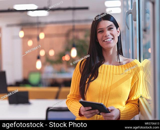 business woman portrait in open space startup coworking office as influencer using smart phone, tablet computer
