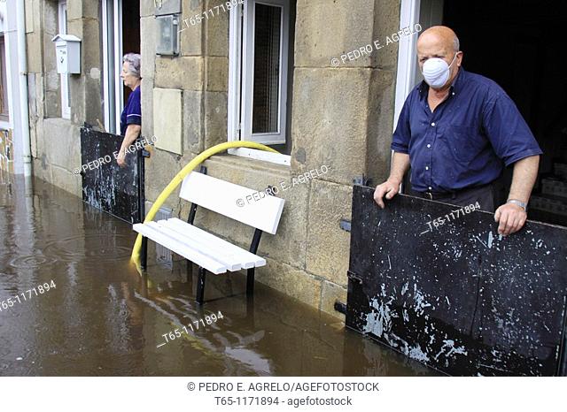 Old couple look at flooded streets after overflowing of River Landro. Viveiro, Province of Lugo, Galicia, Northern Spain